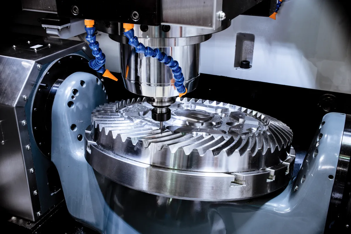 CNC machine precision-cutting a large steel bevel gear